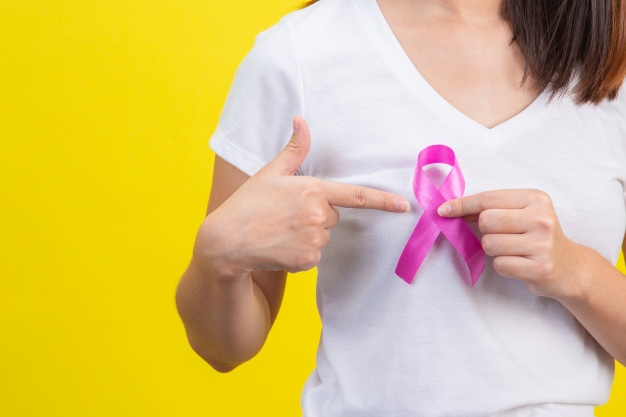 cancer de mama uma mulher em uma camiseta branca com uma fita de cetim rosa no peito um simbolo para a conscientizacao do cancer de mama 1150 18924