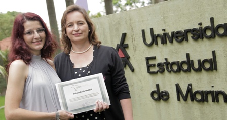 Jaquelini Gisele Gelain exibe o certificado do Prêmio ao lado da orientadora, a professora Márcia Istake