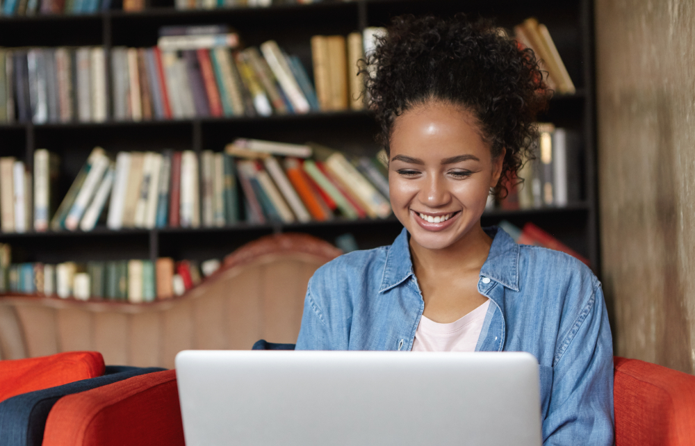 mulher sentada em uma biblioteca com seu laptop 1