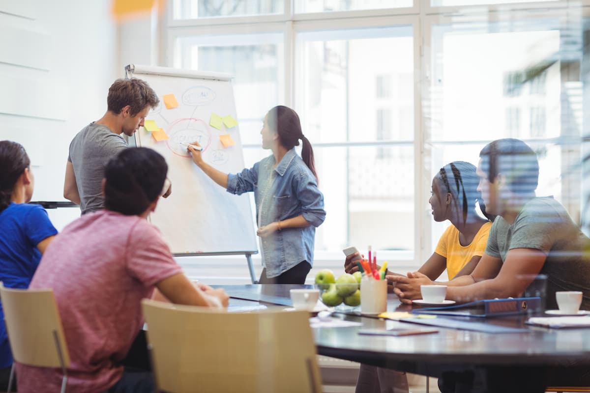 os executivos de negocios discutir com os seus colegas sobre whiteboa 1